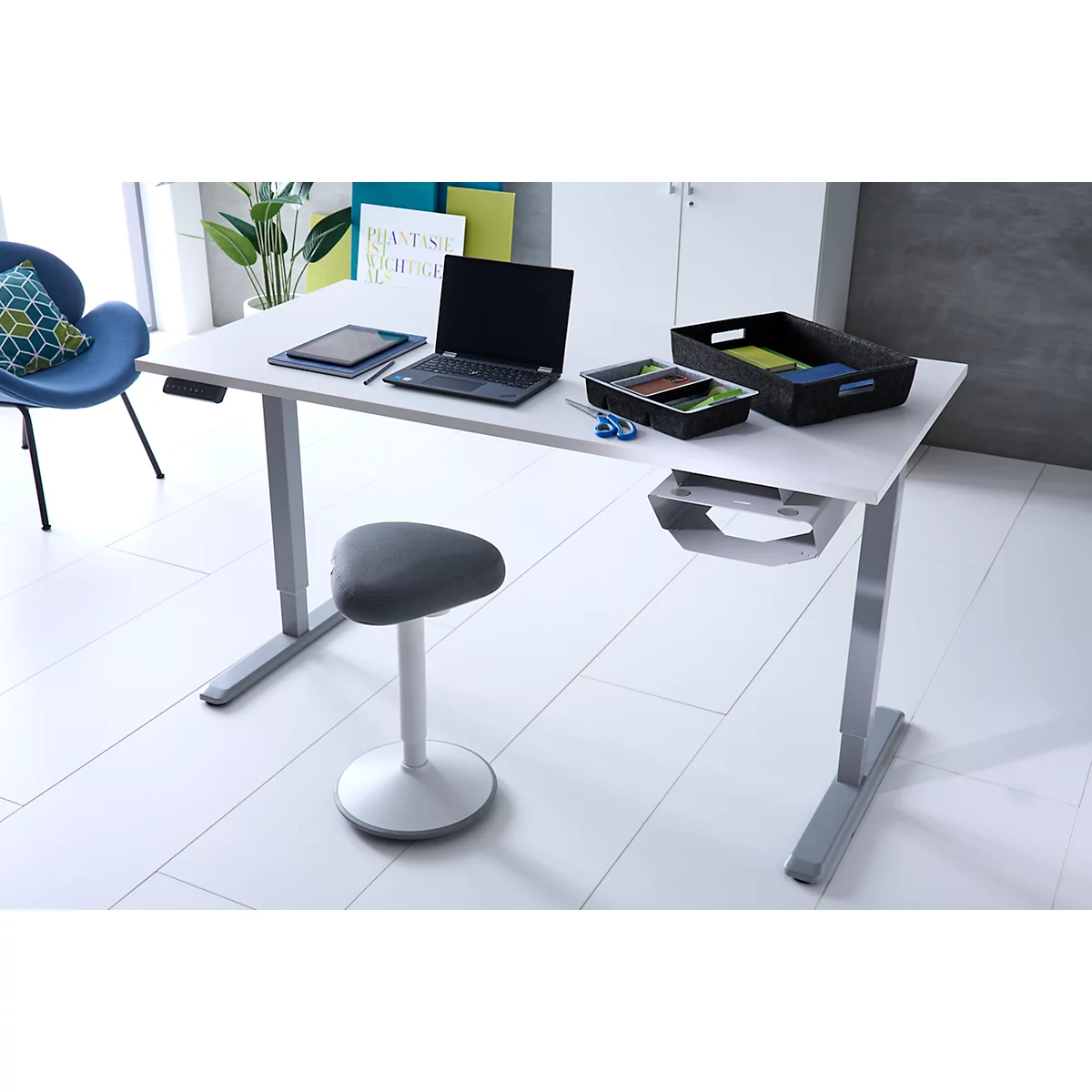 Ein moderner, höhenverstellbarer Schreibtisch mit einem Bürostuhl und Schreibtischzubehör in einem hellen Büro.