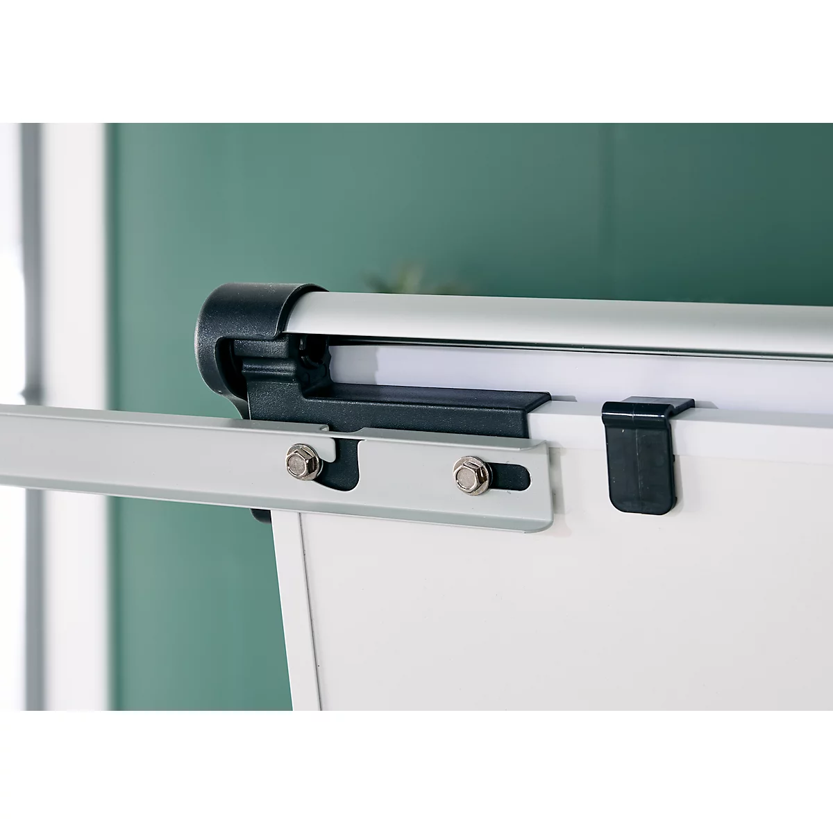 Close-up van een whiteboard met montage en zilveren stang. Op wit papier een zwarte houder.