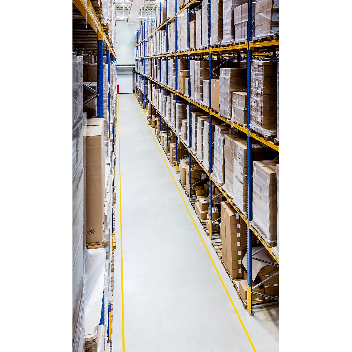 Warehouse with high-bay warehouses full of packages. Yellow marking on the floor. Perspective from above.