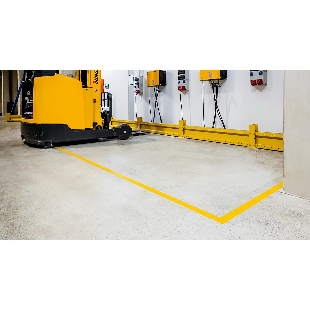 Yellow forklift in a warehouse, marked by yellow lines on the floor.