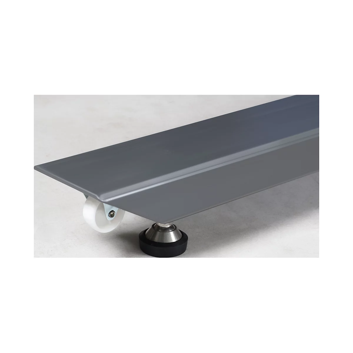 Gray metal plate on wheels and a black rubber foot. The plate is slightly angled.
