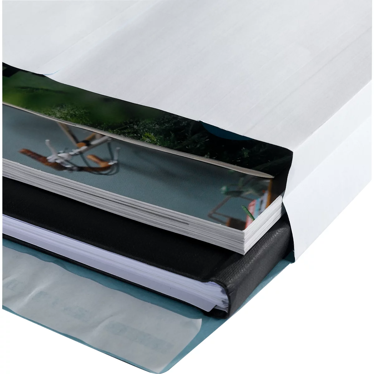 Close-up of a book with different layers of paper inserted in a white cover.