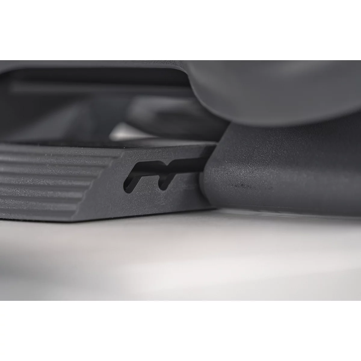 Close-up of a black plastic part with two recesses.