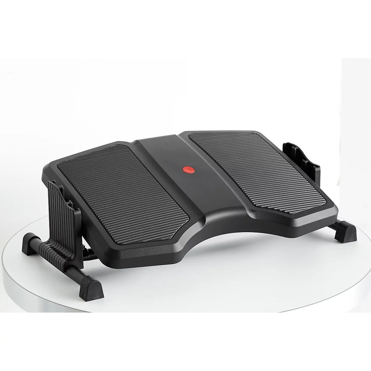 Black footrest with textured surface, red button, against a white background.