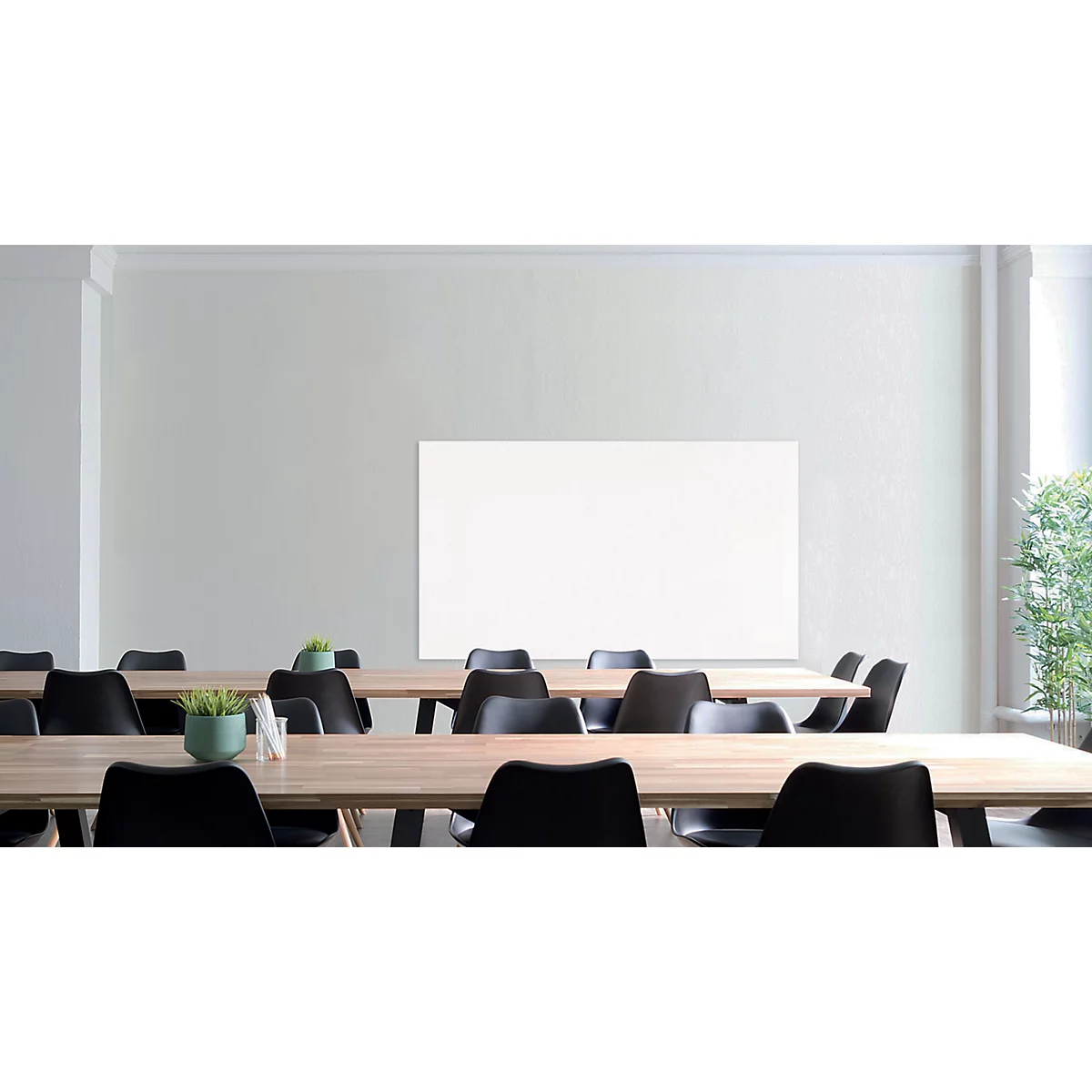 Conference room with tables, chairs, and a whiteboard. Green pot on the table. A window in the background.
