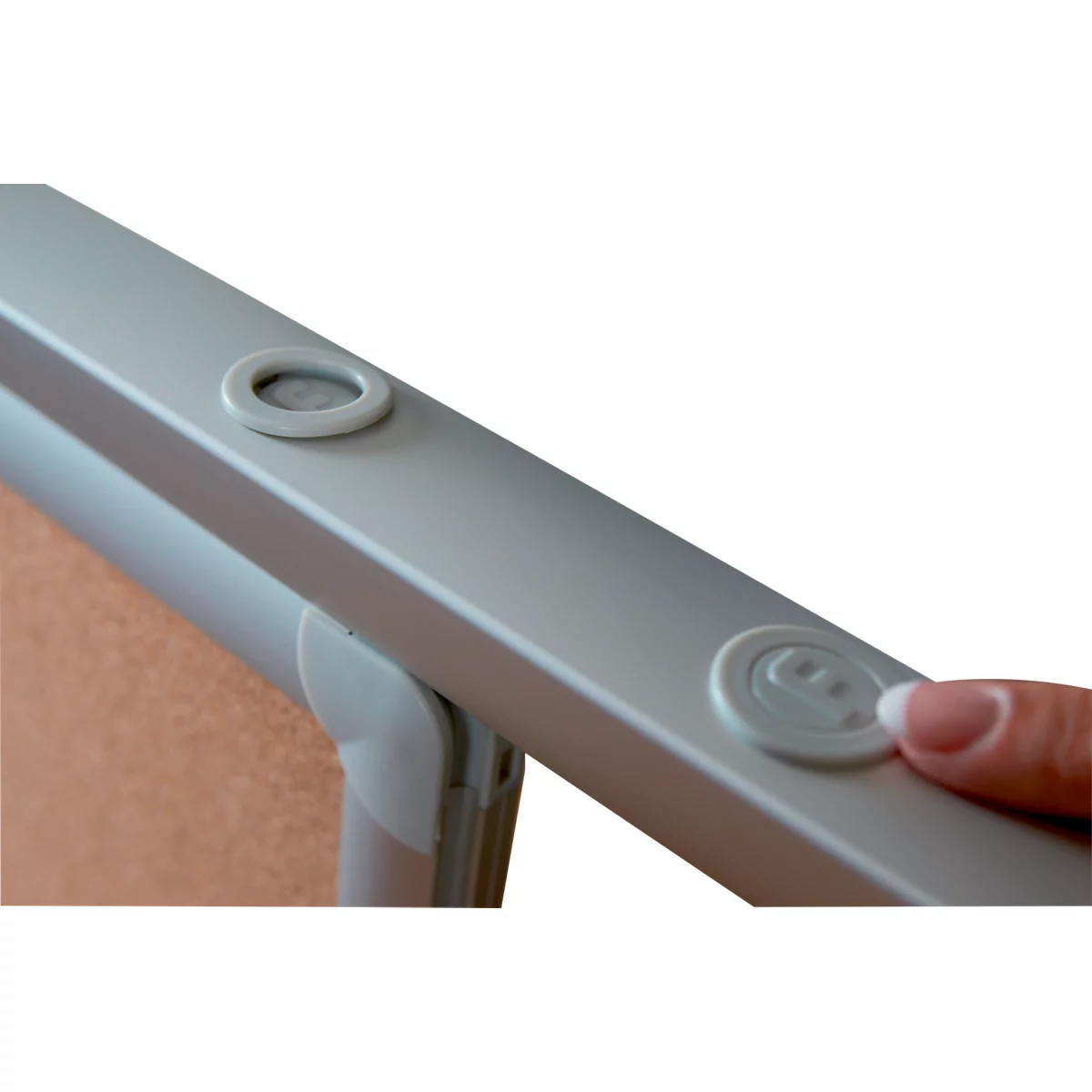 Close-up: Finger pressing a white button on a light grey frame.