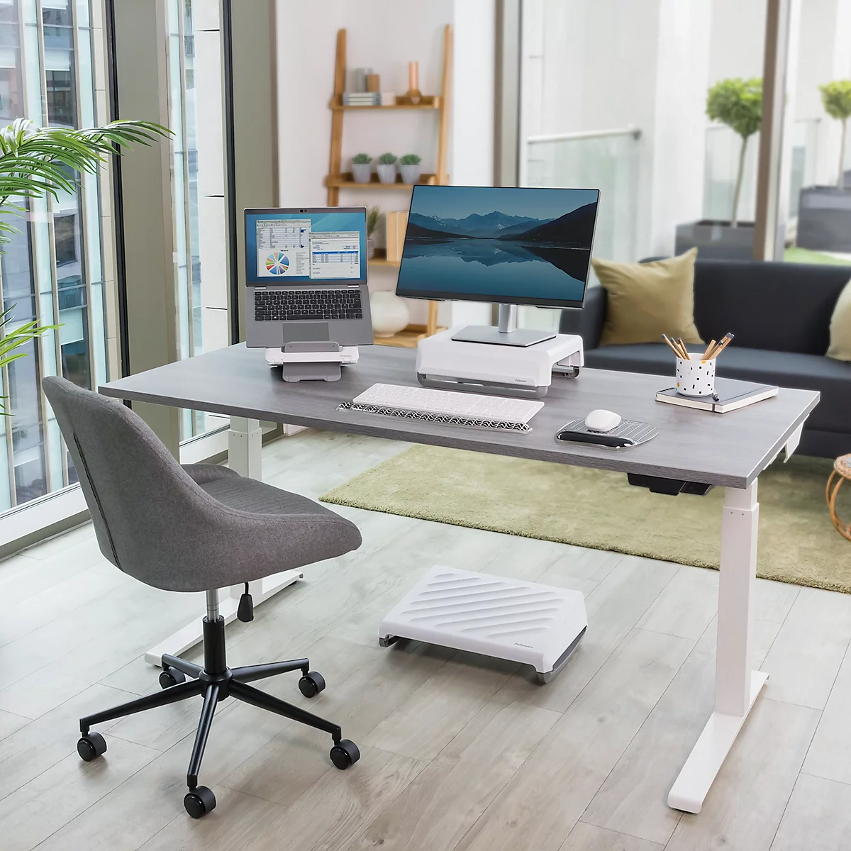 Ein heller Bürotisch mit Laptop, Monitor und Bürostuhl. Auf dem Tisch liegen auch eine Tastatur, eine Maus und Schreibutensilien.