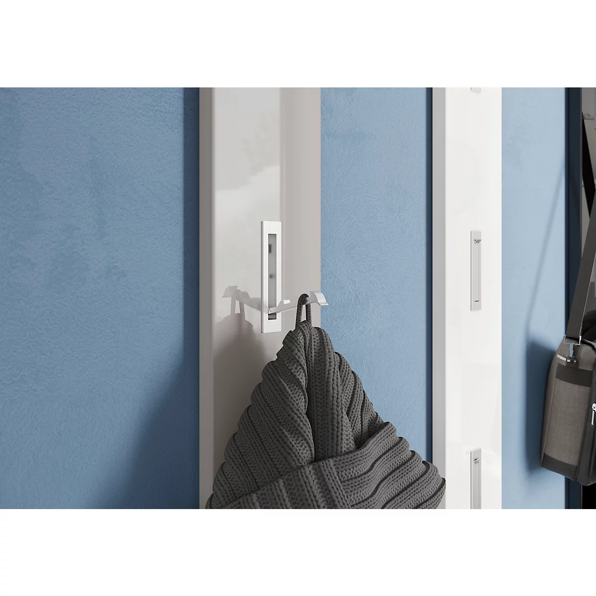 Weißer Wandhaken mit grauem Hut. Blauer Hintergrund.