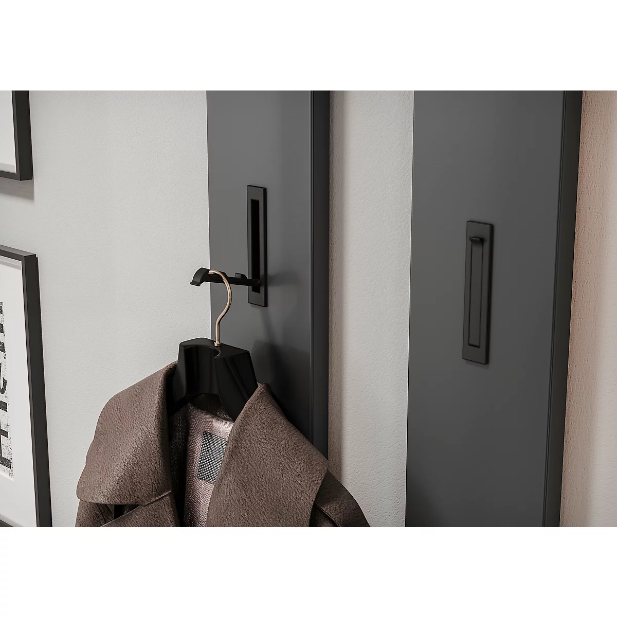 Dunkelgraue Wand mit Haken und einem Mantel. Rechts eine weitere Wand mit einem Griff.