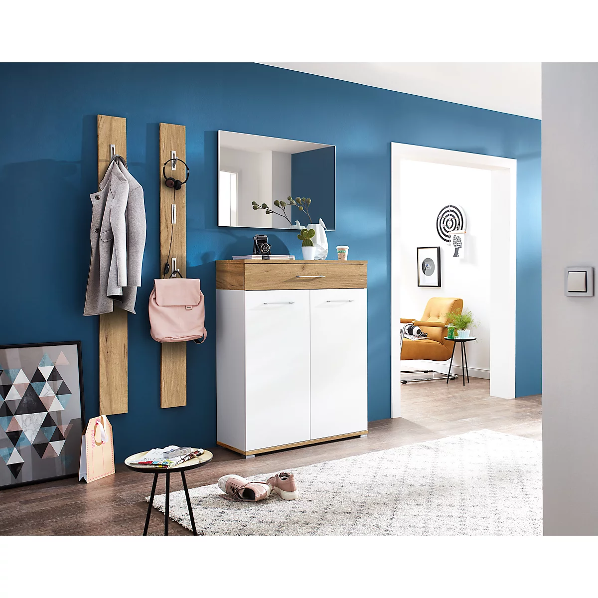 Ein Flur mit Garderobe, Spiegel und Schuhschrank, mit einem Hauch von Wohnlichkeit.