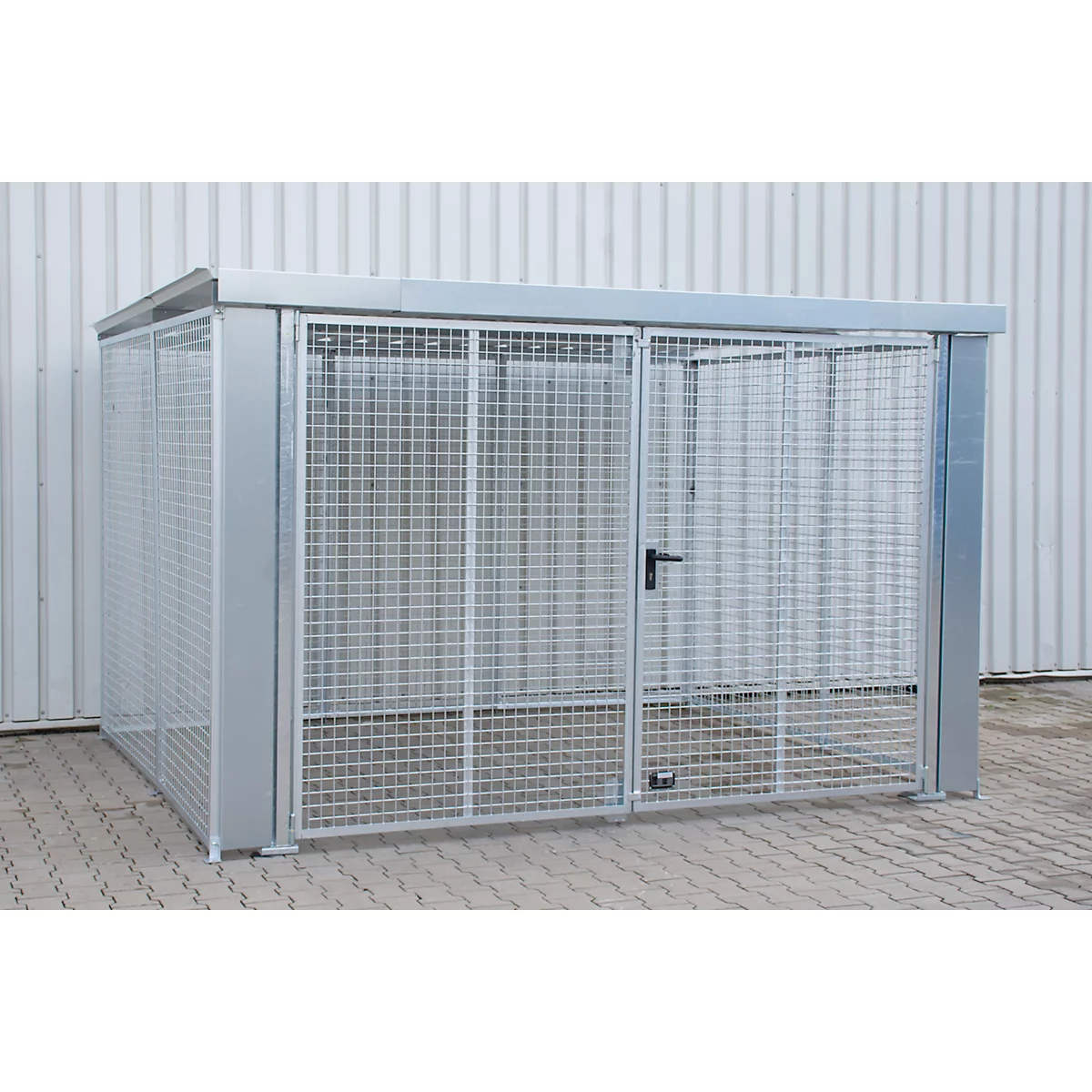 Ein silberner Metallschuppen mit Gitterwänden und einer Tür, vor einem weißen Hintergrund.