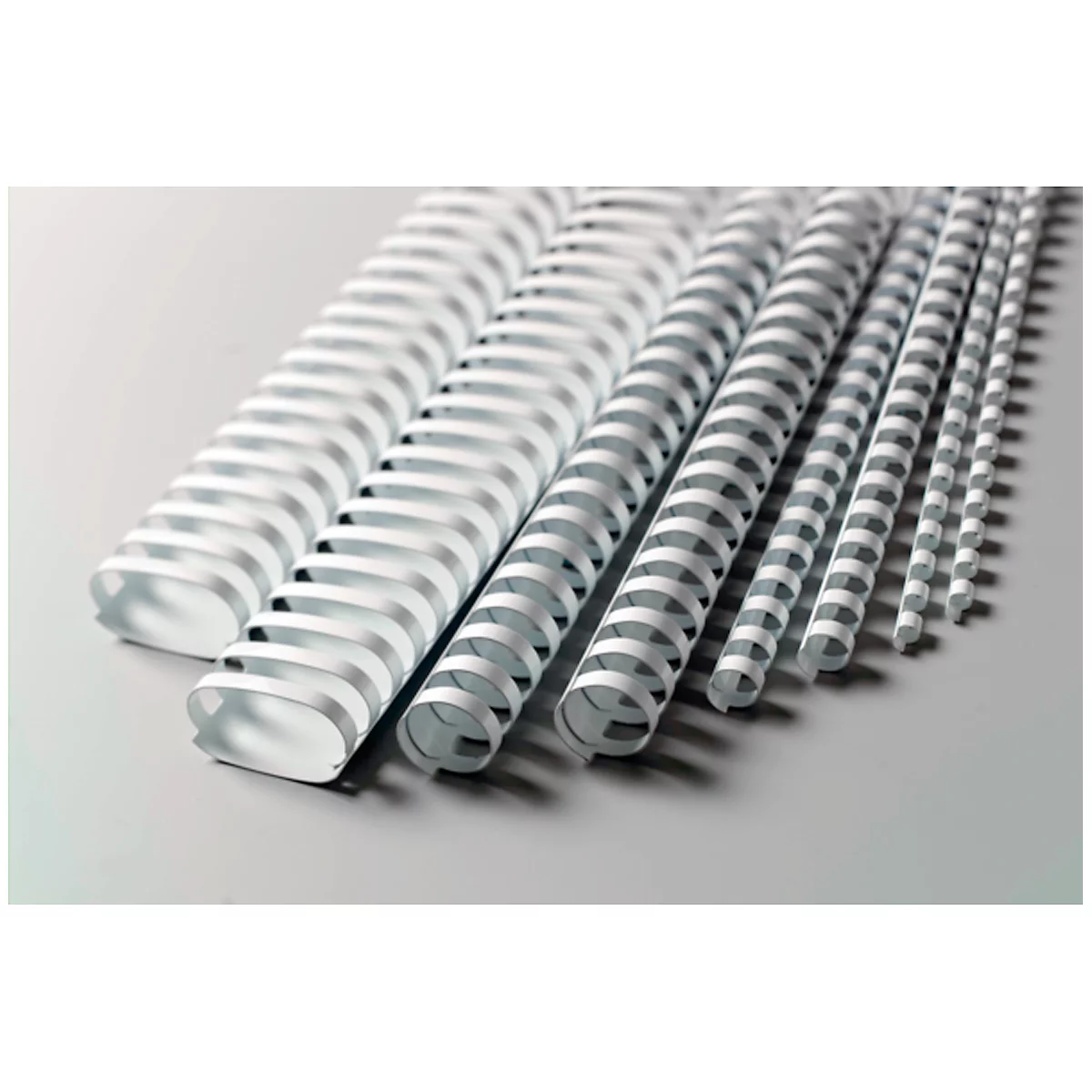 A selection of white binding rings in various sizes, against a light background.