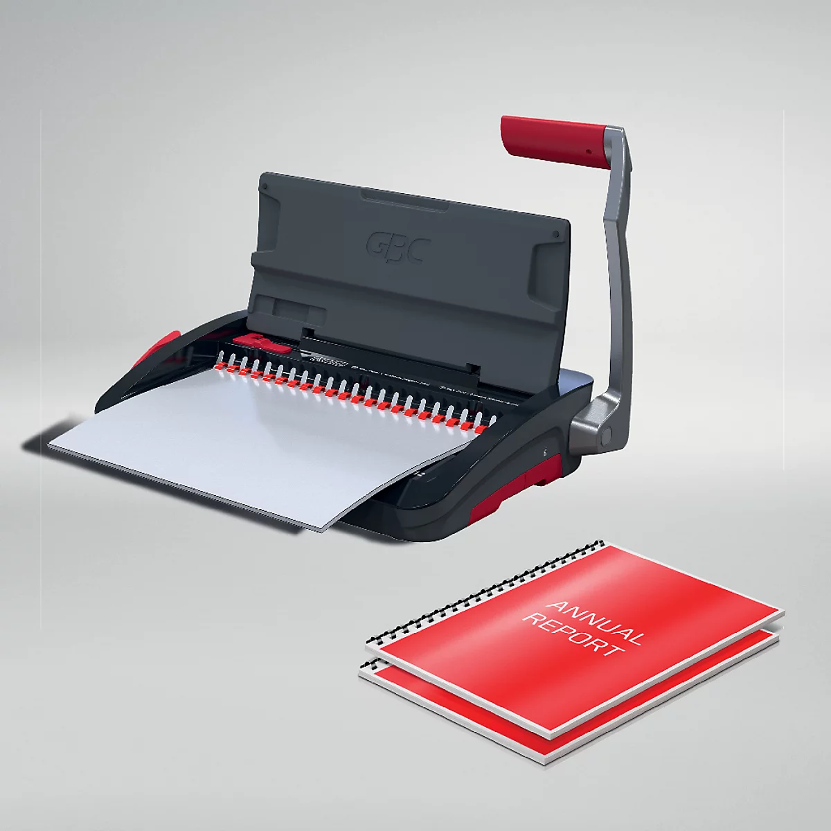 Een grijze bindmachine met rode handgreep, daarnaast een rood jaarverslag.