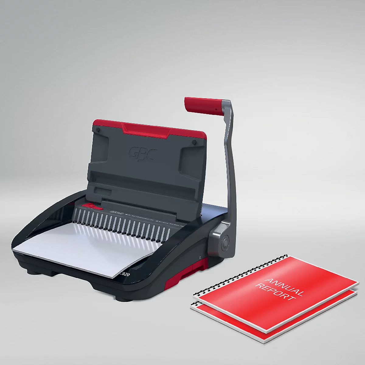 Een bindmachine met rode handgreep en een rood jaarverslagboek.