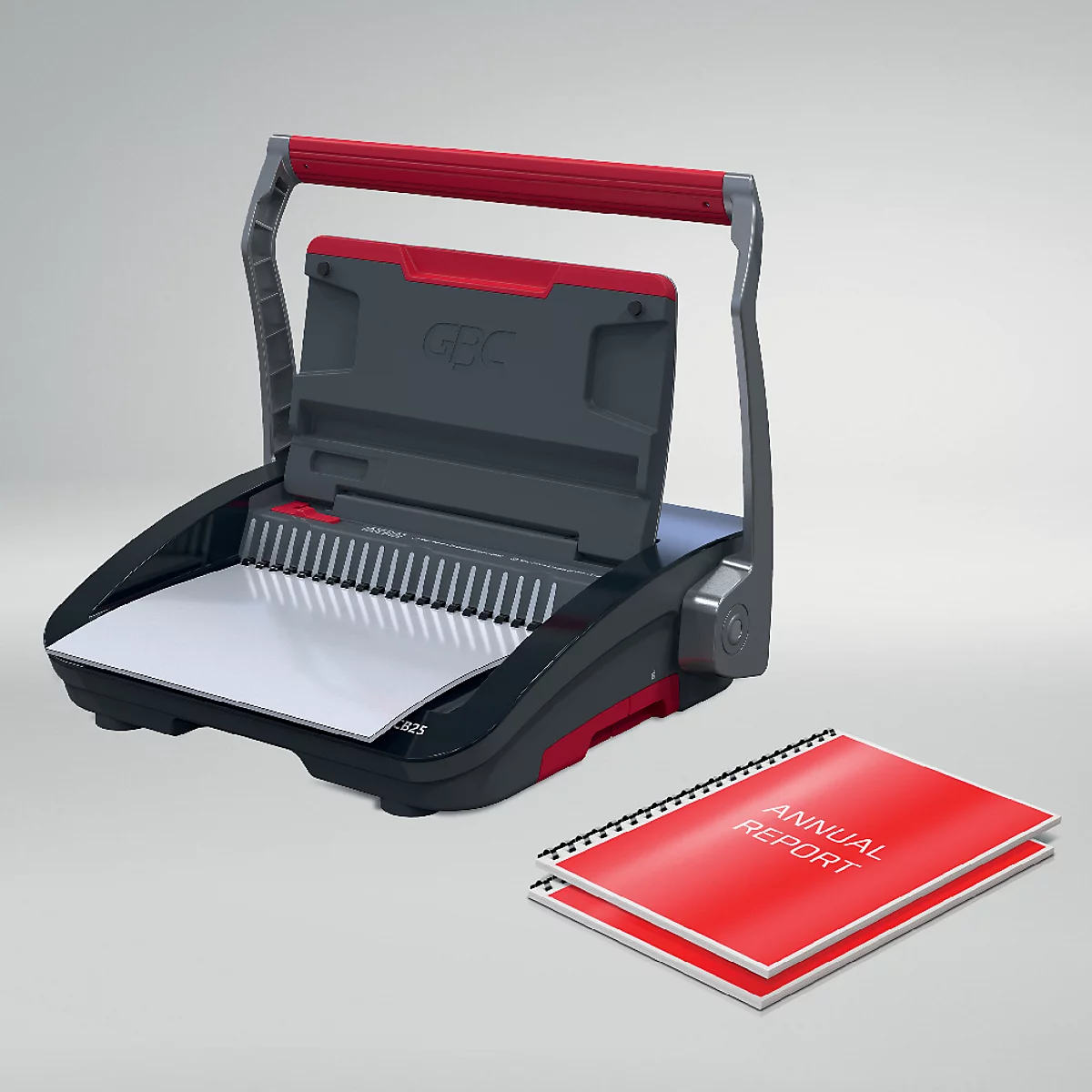 Schwarze Bindemaschine mit rotem Griff und zwei roten Jahresberichten daneben. Auf den Berichten steht "Annual Report".