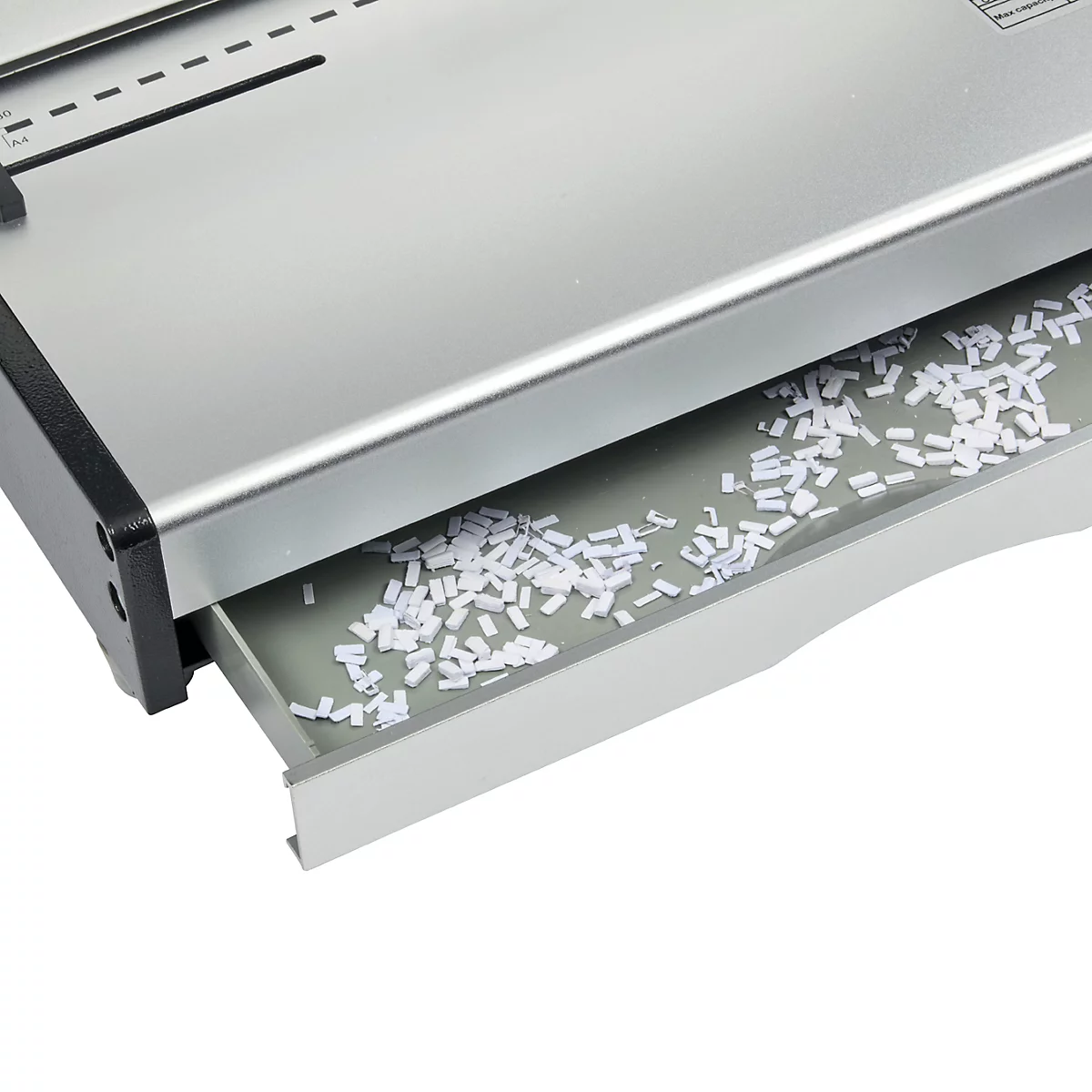 Nahaufnahme eines Papiervernichters, der Schnipsel in der Auffangschale zeigt. Die Maschine ist silberfarben mit schwarzem Rand.