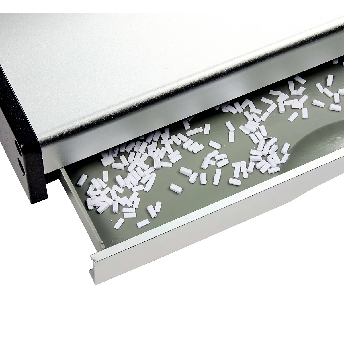 Nahaufnahme eines silbernen Geräts, dessen Schublade mit weißen, zylinderförmigen Objekten gefüllt ist.