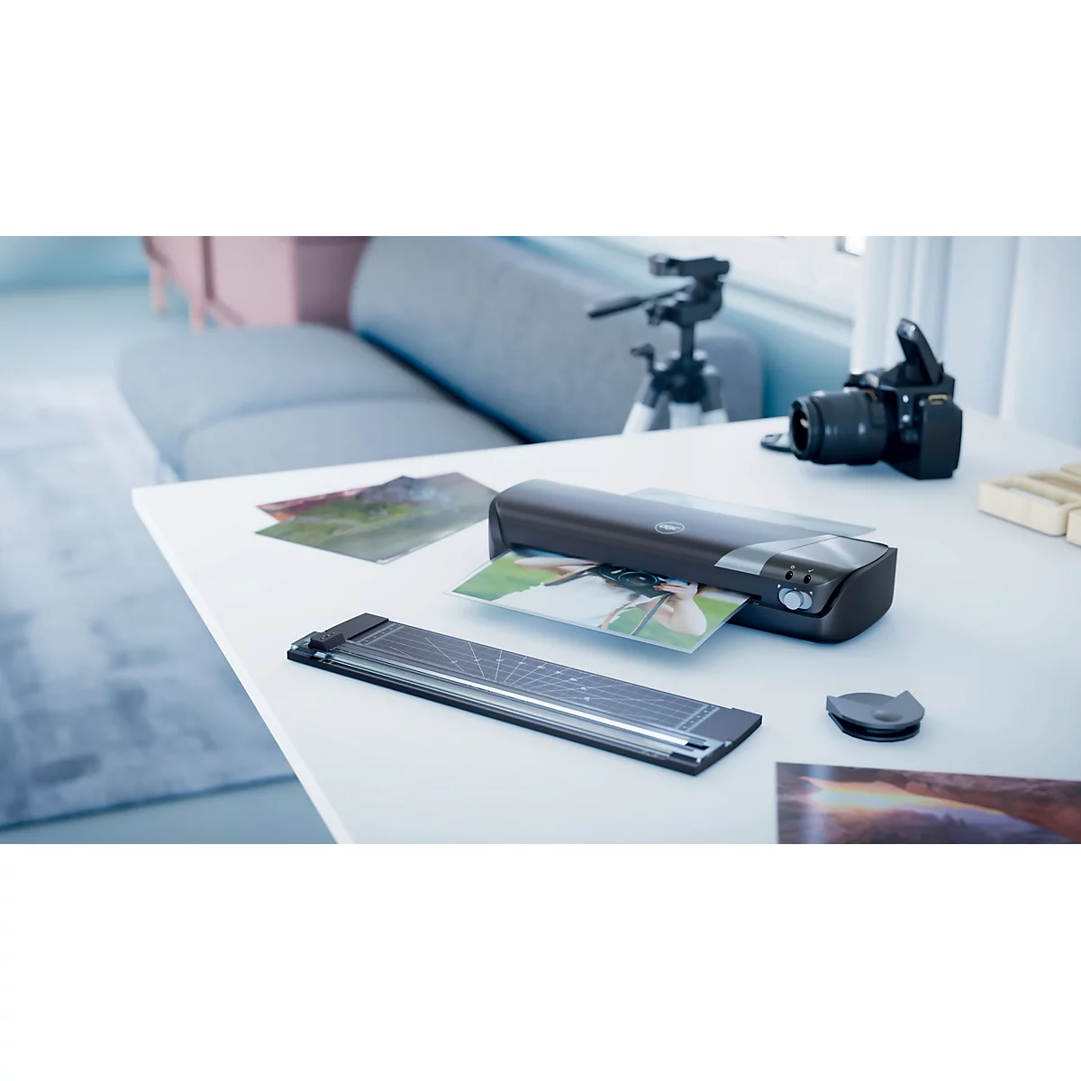 Une table avec appareil photo, trépied et photos. Un scanner scanne une photo.