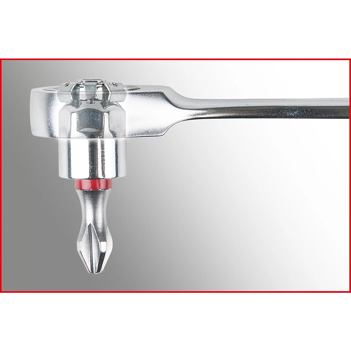 Nahaufnahme eines silbernen Schraubenschlüssels mit rotem Akzent. Auf grauem Hintergrund.