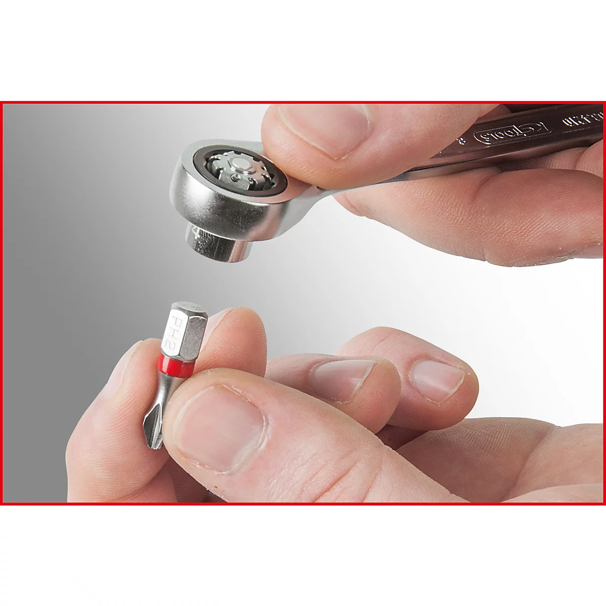 Nahaufnahme eines Schraubenschlüssels und einer Schraube, die von Händen gehalten werden.