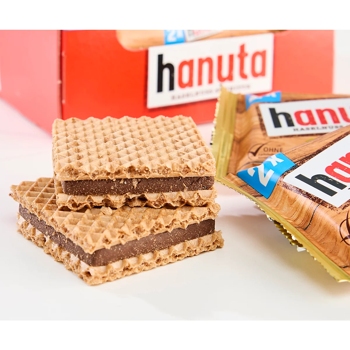 Two stacked Hanuta hazelnut wafers in front of a red brand packaging.