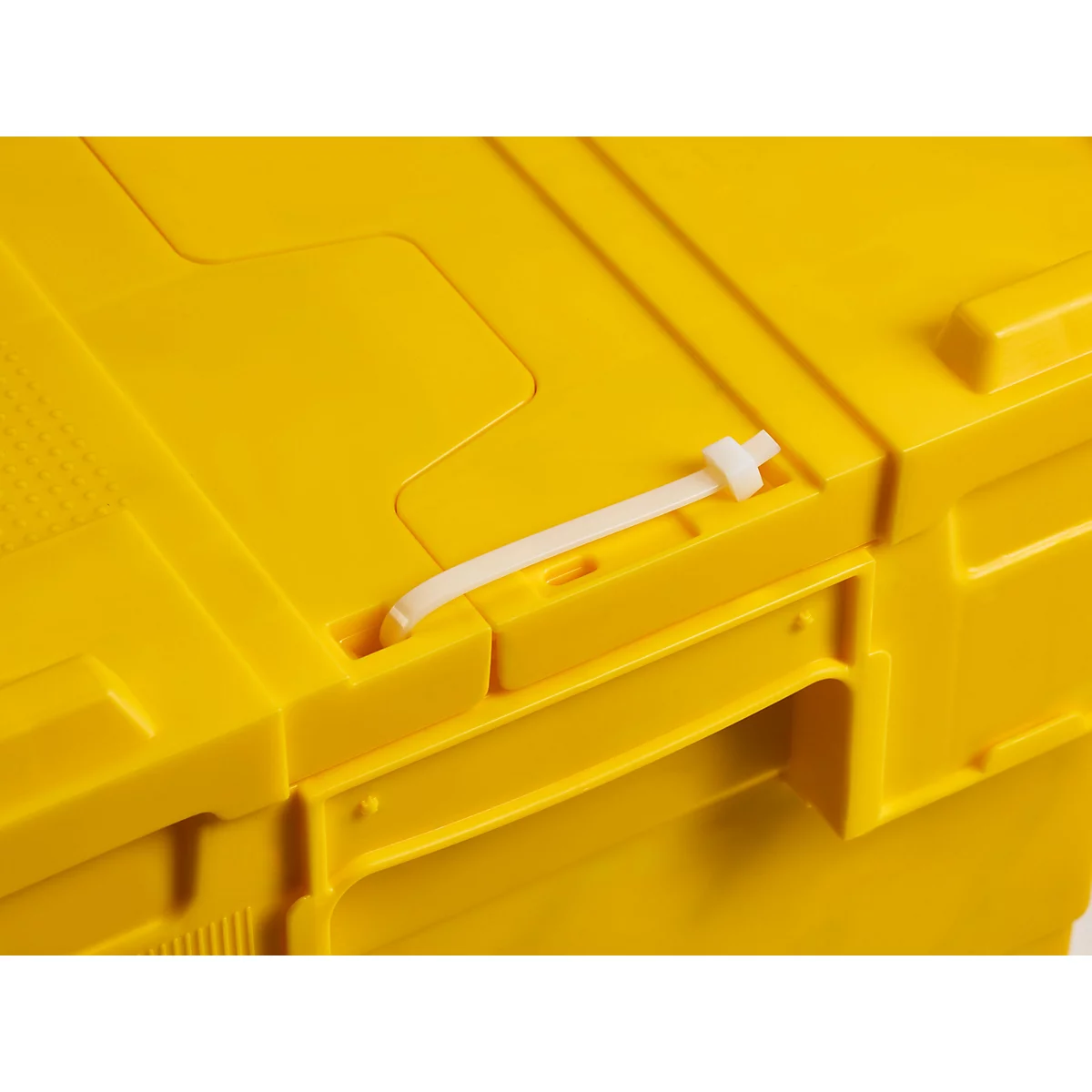 Gelbe Transportbox, verschlossen mit weißem Kabelbinder. Detailaufnahme.