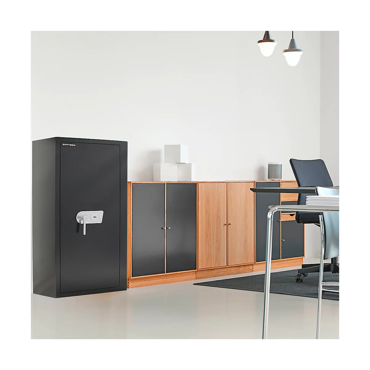 Schwarzer Tresor mit silbernem Griff in einem Büro. Im Hintergrund Schränke und Schreibtisch.