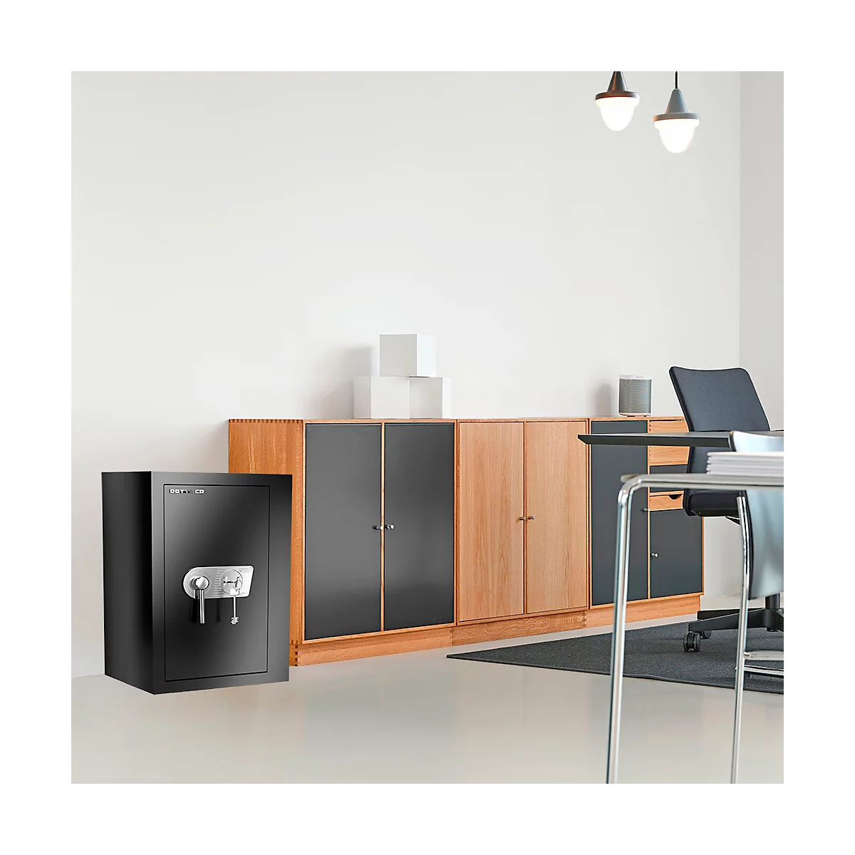 Schwarzer Tresor in einem Büro. Holzschrank und Schreibtisch im Hintergrund.
