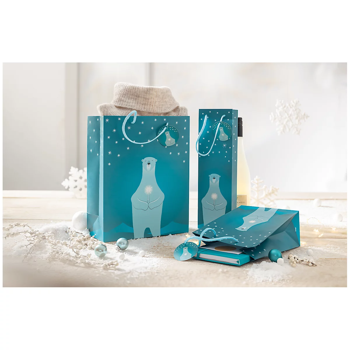Cadeautassen met ijsbeermotieven, gedeeltelijk gevuld met items. Decoratie met sneeuwvlokken en sneeuw op de achtergrond.