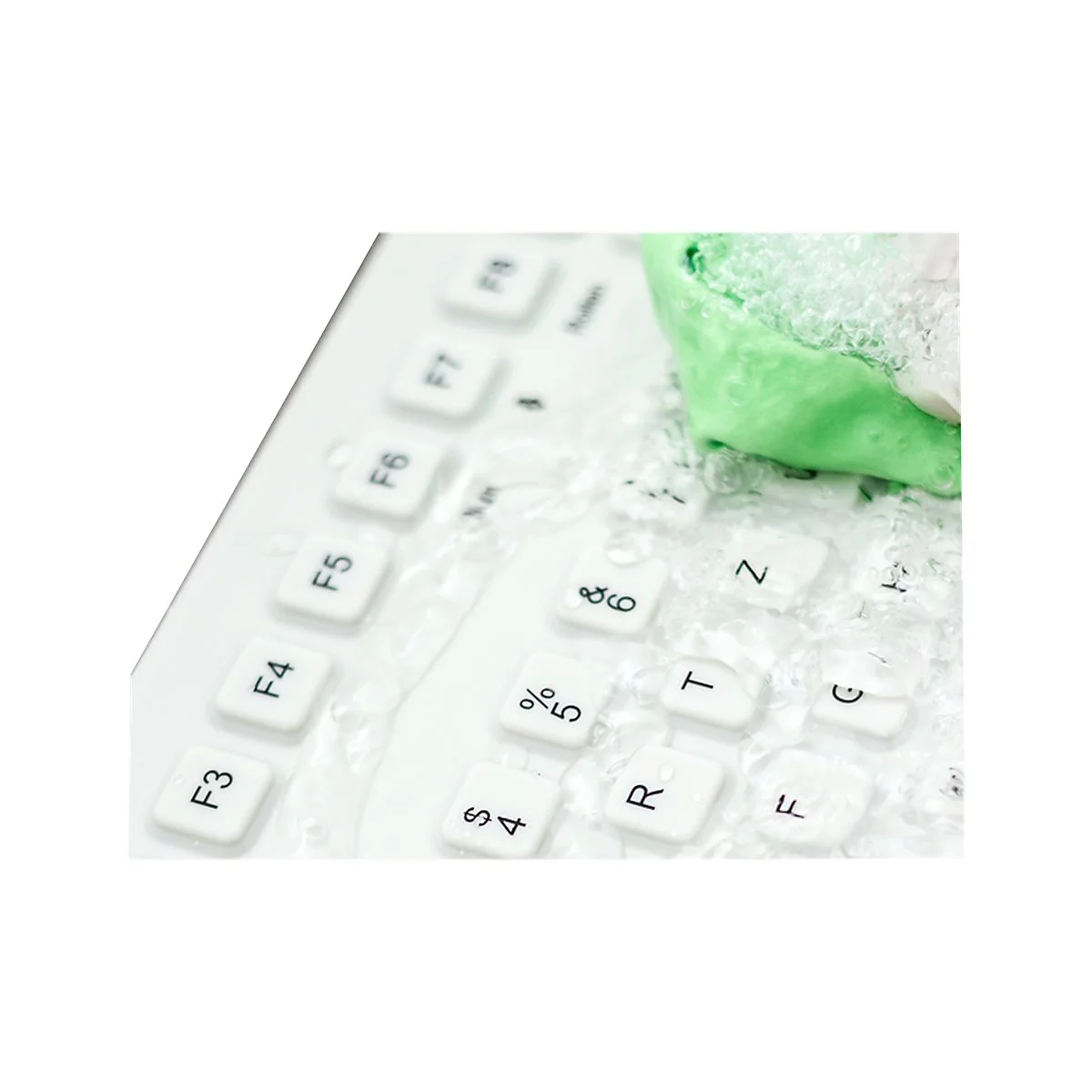 Eine weiße Tastatur wird mit einem grünen Tuch und viel Schaum gereinigt.