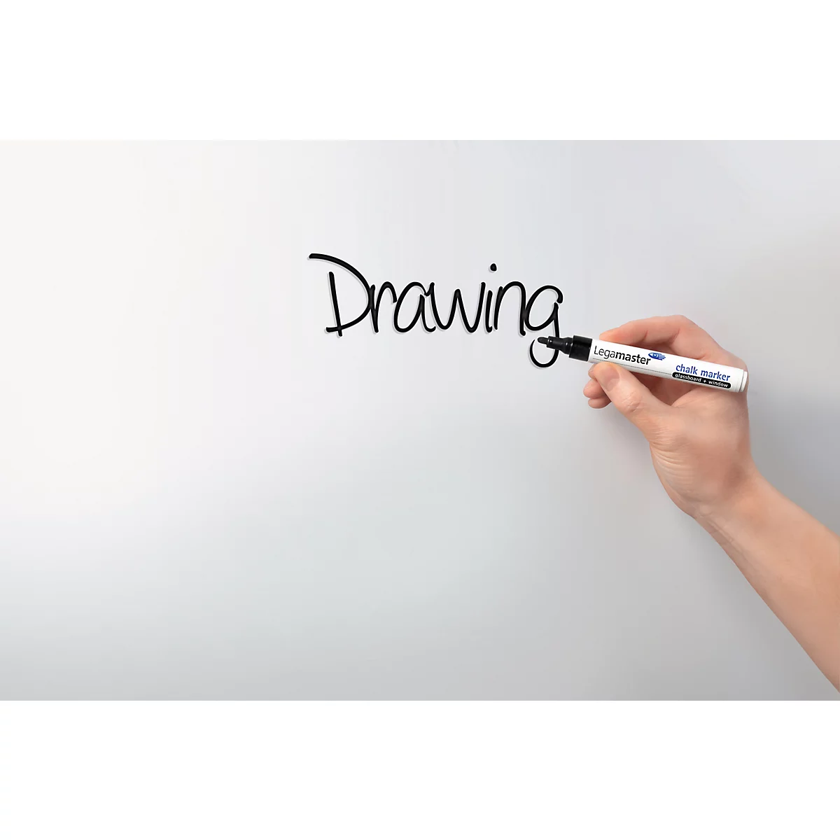 A hand is writing the word "Drawing" with a black felt-tip pen on a white board.