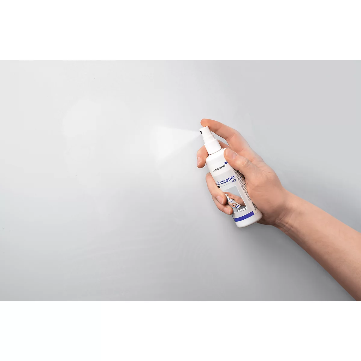 Hand spraying cleaner on grey surface. "t-cleaner" is written on the bottle.