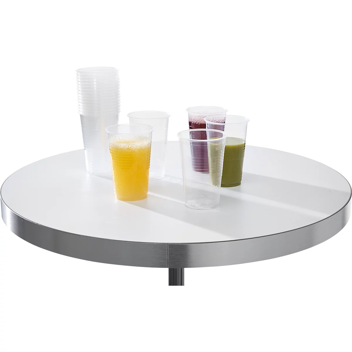 Gobelets en plastique transparents avec divers jus sur une table ronde blanche.