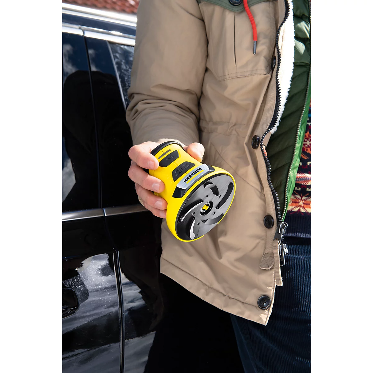 Une personne tient un appareil jaune et rond. Il comporte des éléments noirs et une hélice grise.