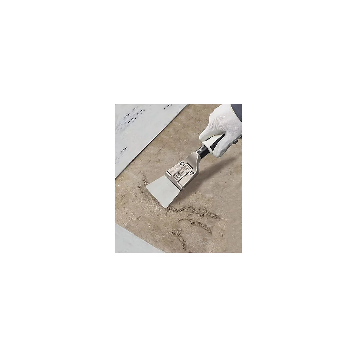 Main tenant avec un gant blanc un grattoir glissant sur une surface beige.