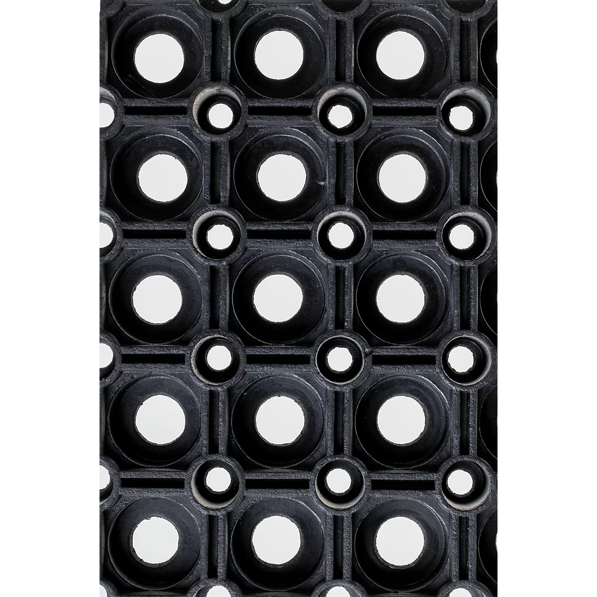 Nahaufnahme einer schwarzen Gummimatte mit einem regelmäßigen Muster aus großen und kleinen runden Löchern.