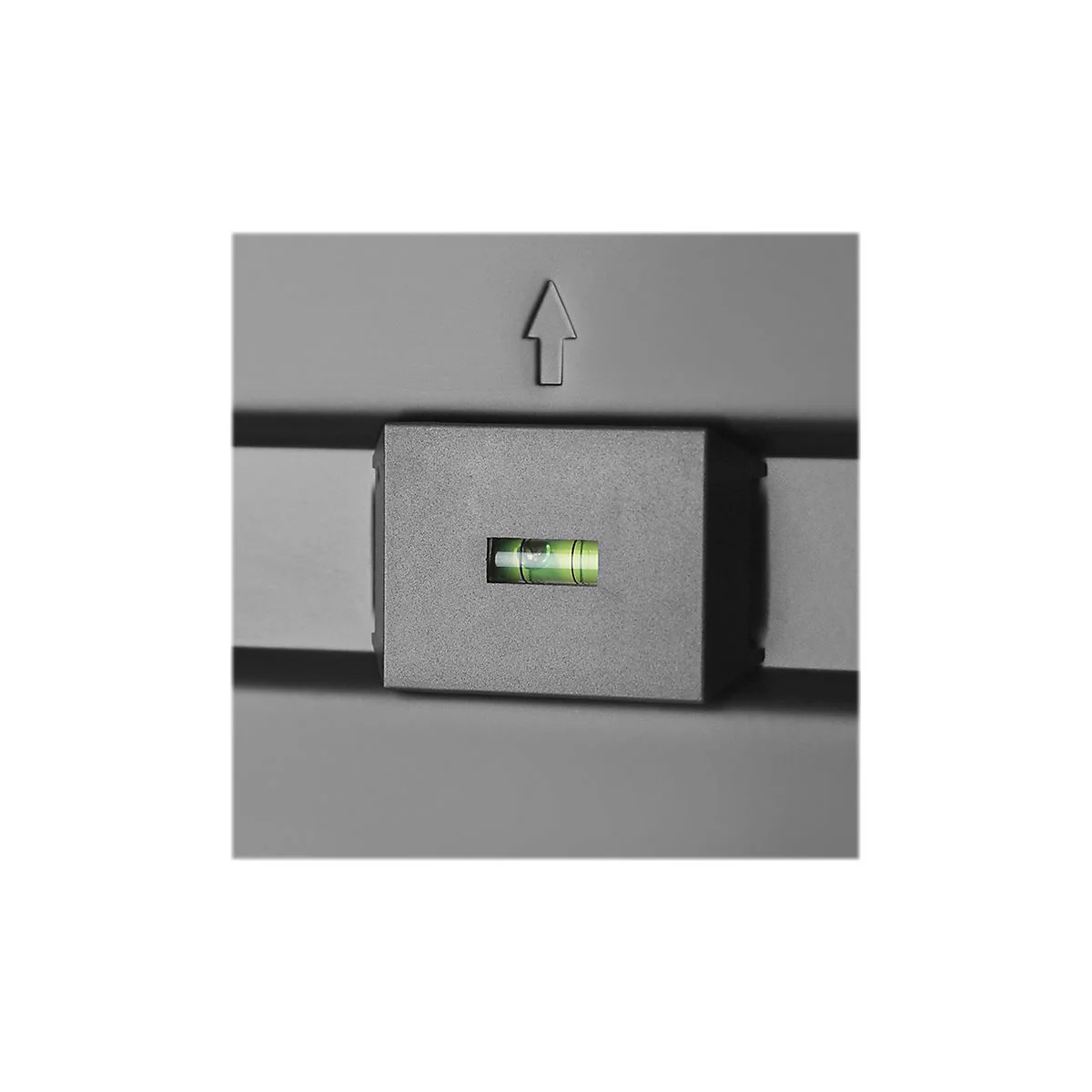 Detailaufnahme einer Wasserwaage in einem quadratischen, grauen Gehäuse, mit einer Pfeilmarkierung.