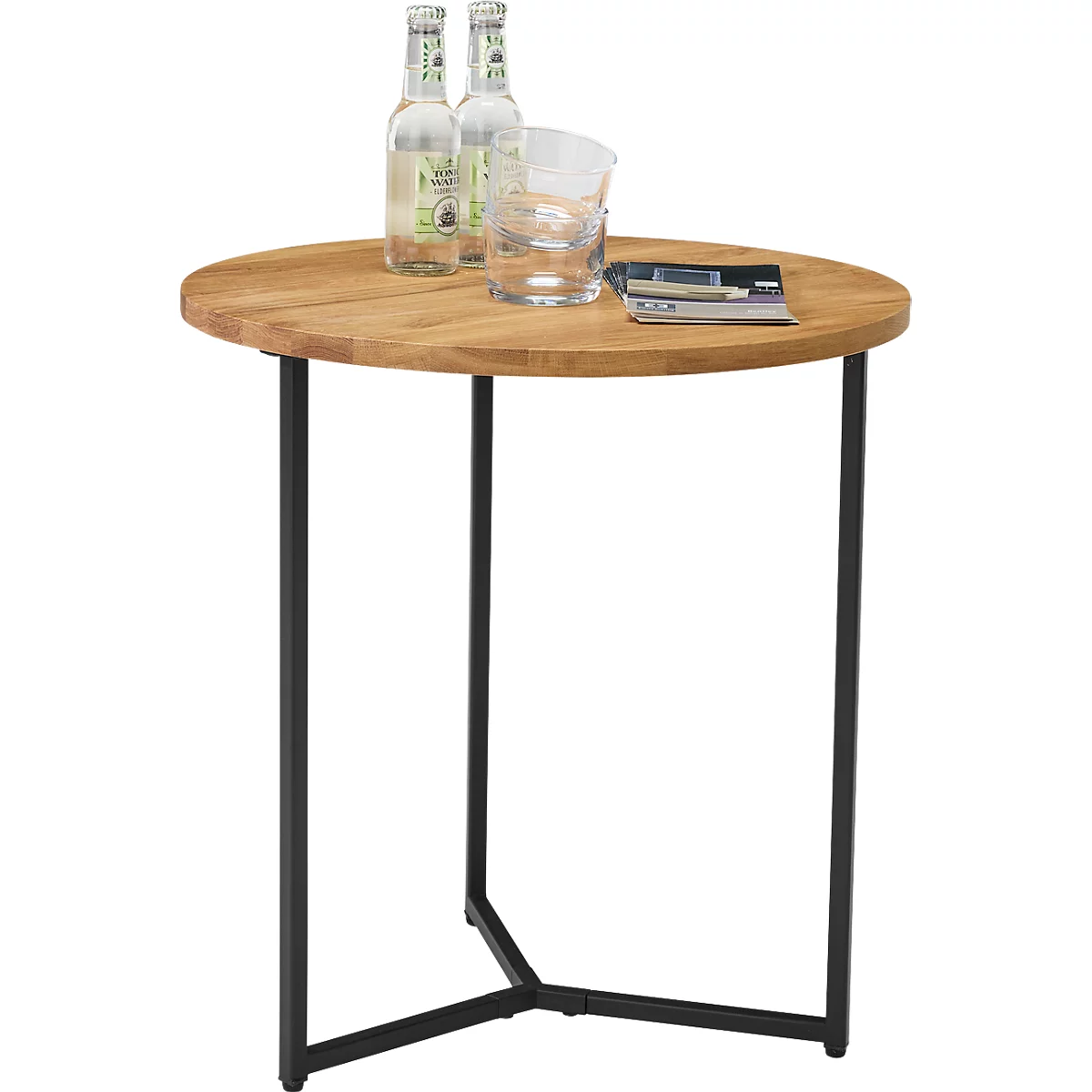 Ronde bruine bijzettafel met zwarte metalen poten. Op het tafelblad staan twee drankflessen, een glas en een tijdschrift.