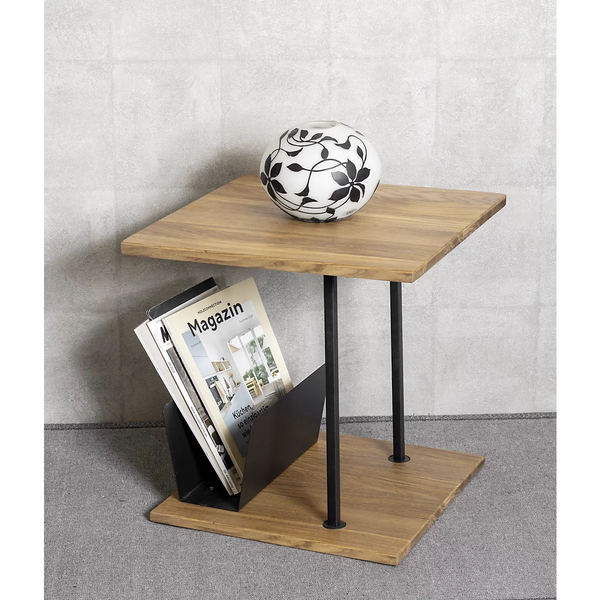 Houten tafel met zwart frame, een tijdschrift en een bal met bloemenpatroon.