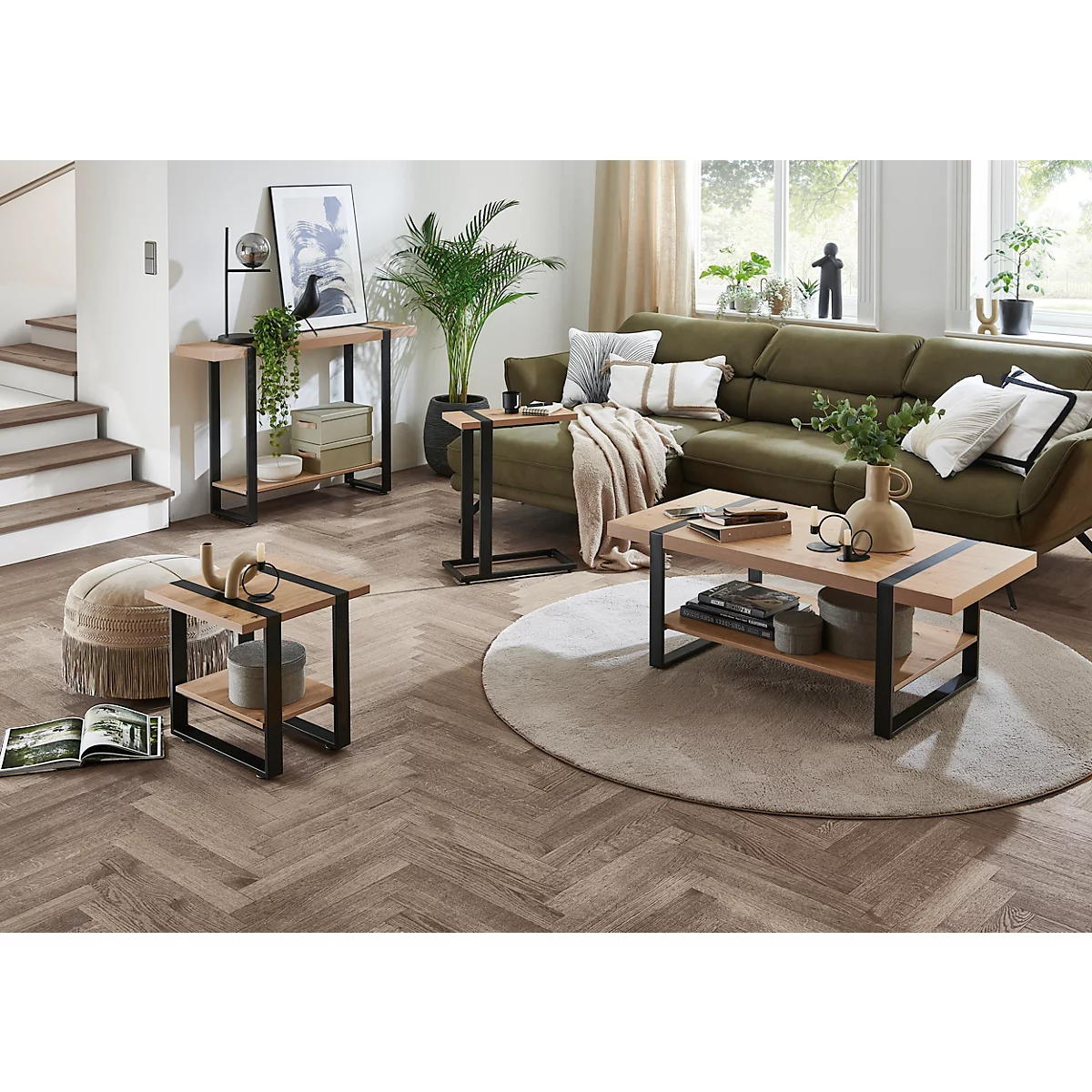 Woonkamer met groene bank, houten tafels en planten. Uitnodigende sfeer.
