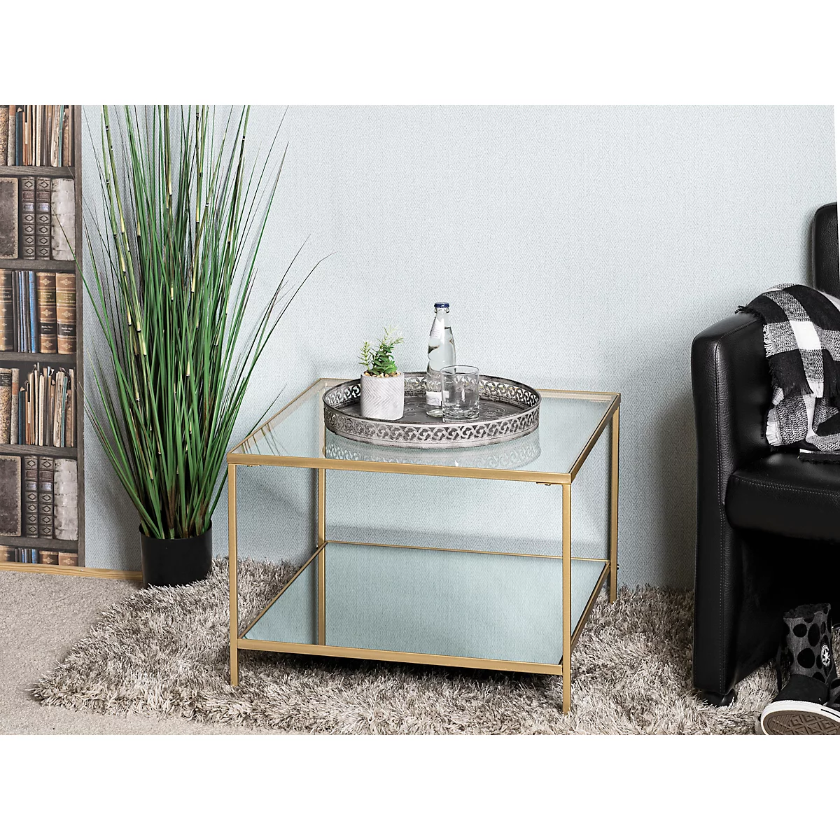Table basse carrée avec un cadre en métal doré et deux étagères en verre.