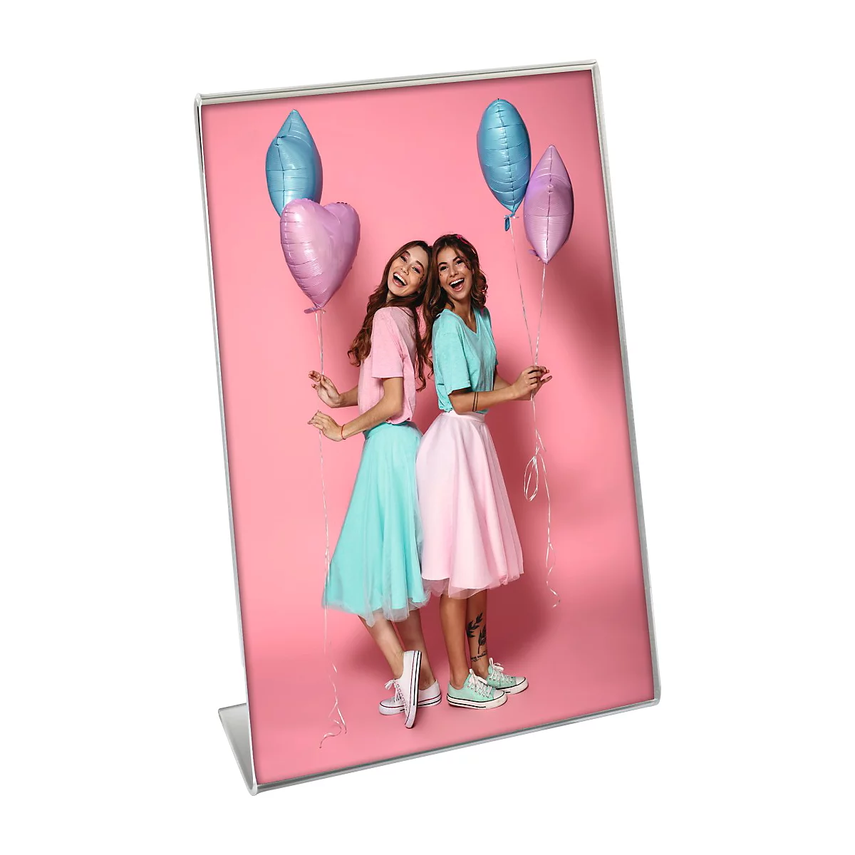 Deux jeunes femmes, bras dessus bras dessous, sourient et tiennent des ballons sur fond rose.