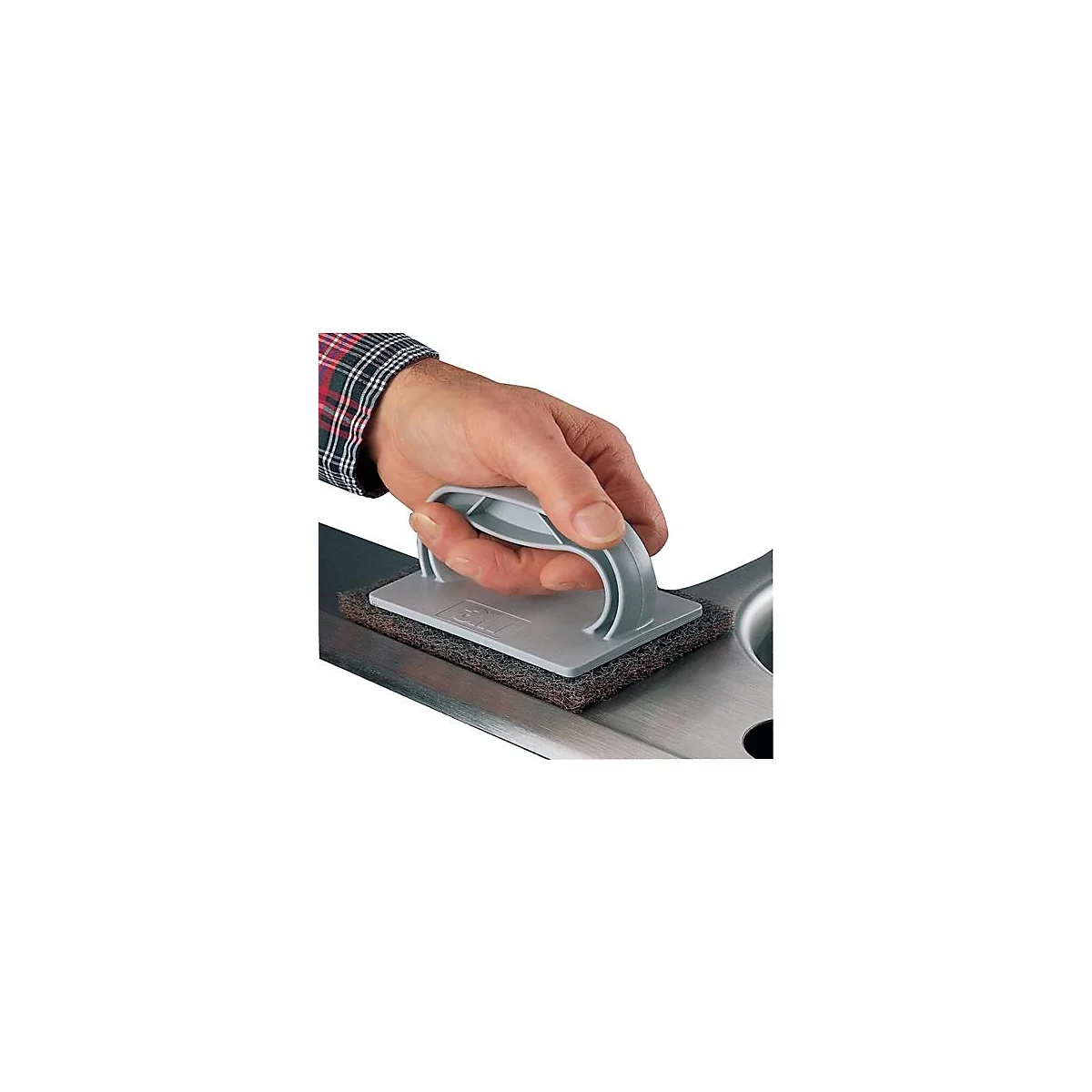 Hand houdt een grijze reinigingsspons vast, die op een metalen oppervlak wordt gebruikt.
