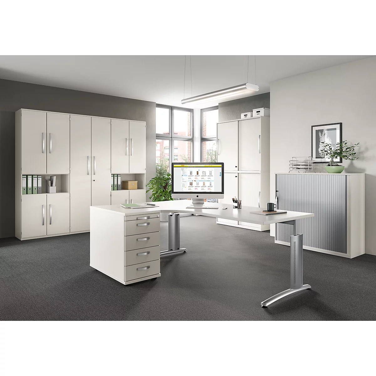 Bright office with white desk, file cabinets, and a computer screen.