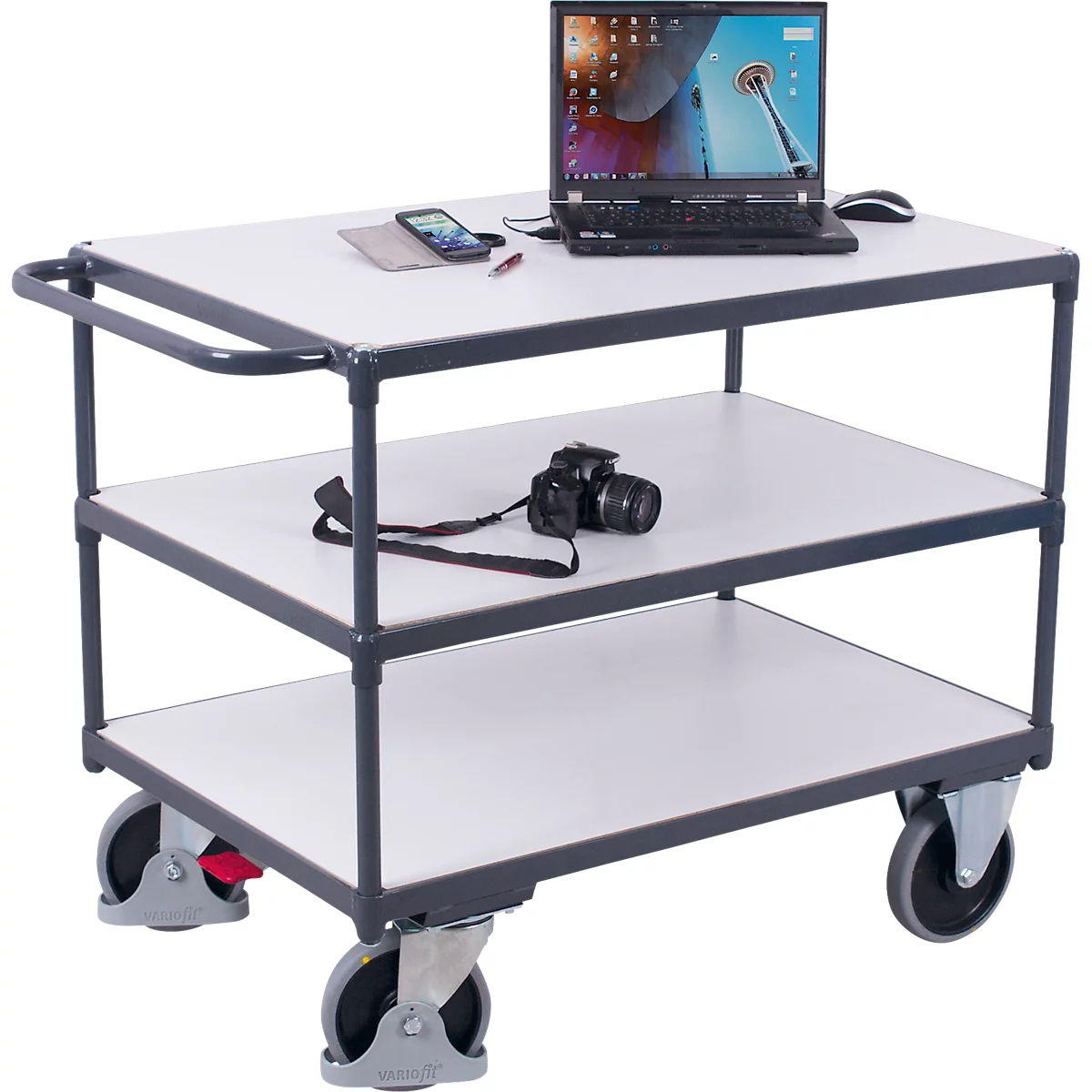 Three-tier service cart with gray frame, white shelves, and wheels, holding a laptop, camera, and phone.