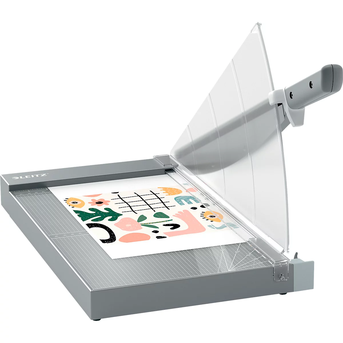 Grauer Papierschneider, mit transparentem Schutz. Auf dem Papier ein farbenfrohes Muster.