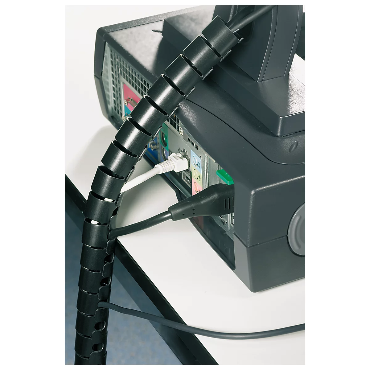 Black cable spiral organizing computer and power cables, attached to a PC.