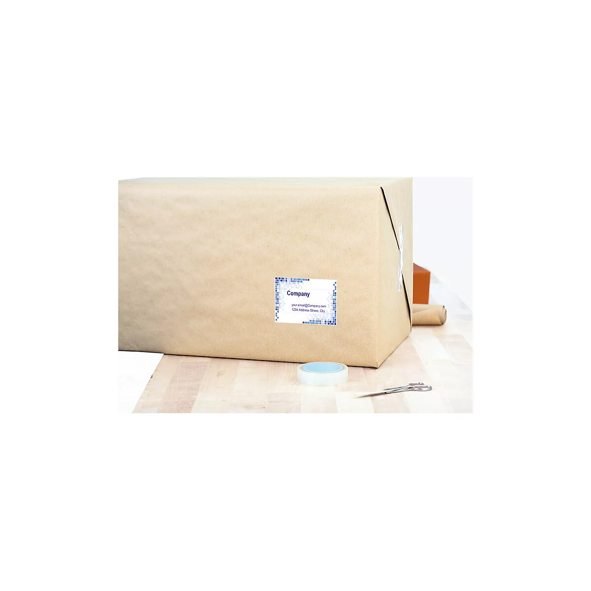 Ein braunes Paket mit Adressetikett liegt auf einem Holztisch. Auf dem Tisch liegen Klebeband und eine Schere.