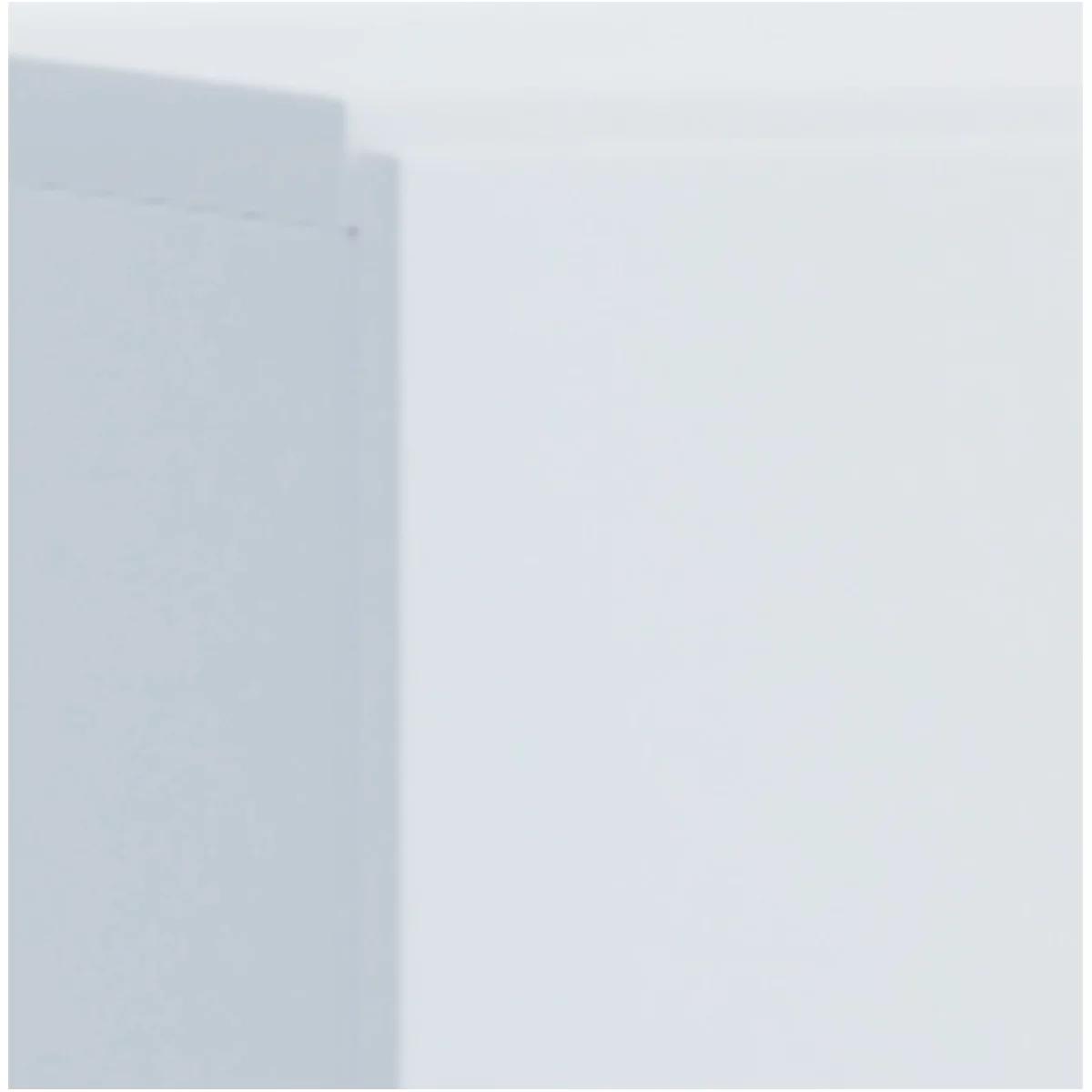 Corner of a white wall with part of a light grey door or cabinet. The right half of the image is white.