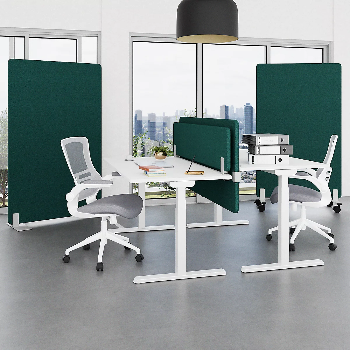 Büro mit Schreibtischen, Stühlen und grünen Trennwänden. Fenster im Hintergrund mit Stadtblick.